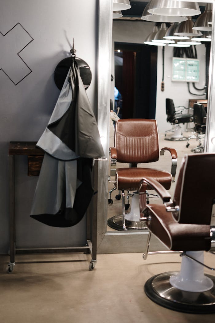 Contemporary barbershop interior showcasing stylish chairs and mirrors ready for clients.