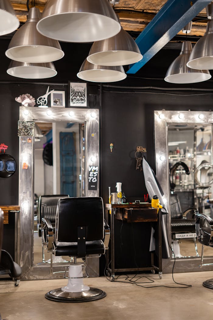 Contemporary hair salon featuring sleek chairs, bright mirrors, and industrial lighting.