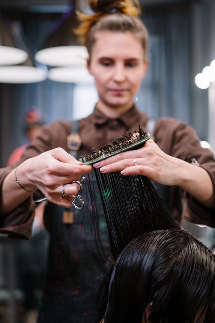 A hairstylist expertly cutting a client's hair in a modern salon setting.